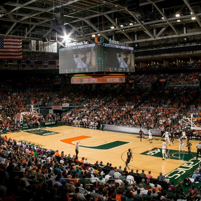 Basketball game in progress at a large indoor arena with a crowd and visible branding.