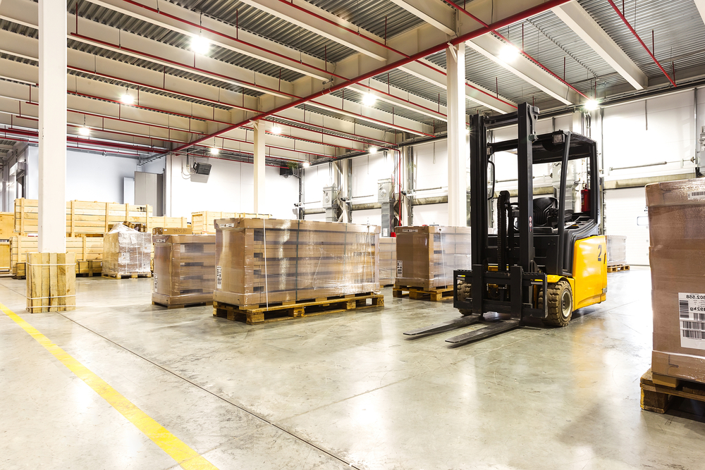 Forklift in a warehouse with pallets and boxes