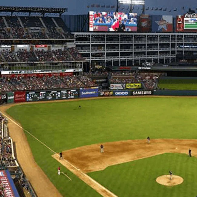 Baseball game in progress at a stadium with visible advertisements and a large screen.
