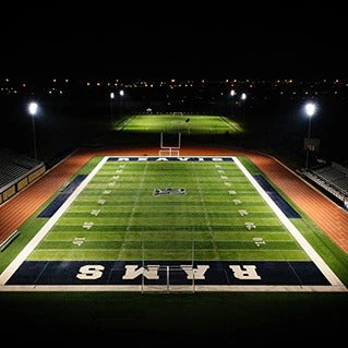 Football field at night with 'Rams' branding